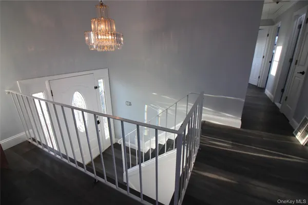 a view of staircase with railing and a chandelier