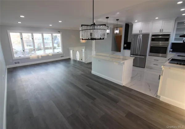 a kitchen with stainless steel appliances kitchen island wooden floors wooden cabinets and window