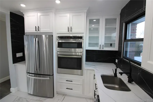 a kitchen with stainless steel appliances a refrigerator sink and cabinets