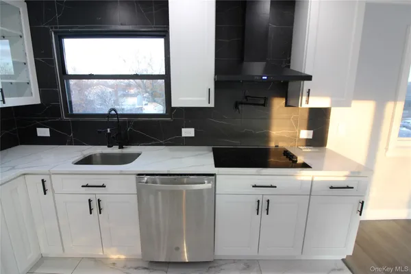 a kitchen with cabinets appliances a sink and a window