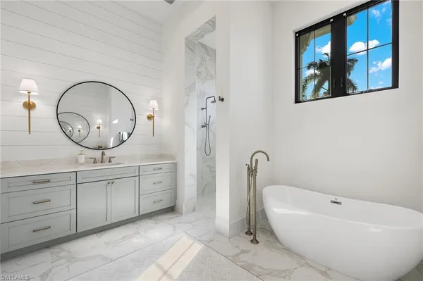 a spacious bathroom with a bathtub sink and mirror