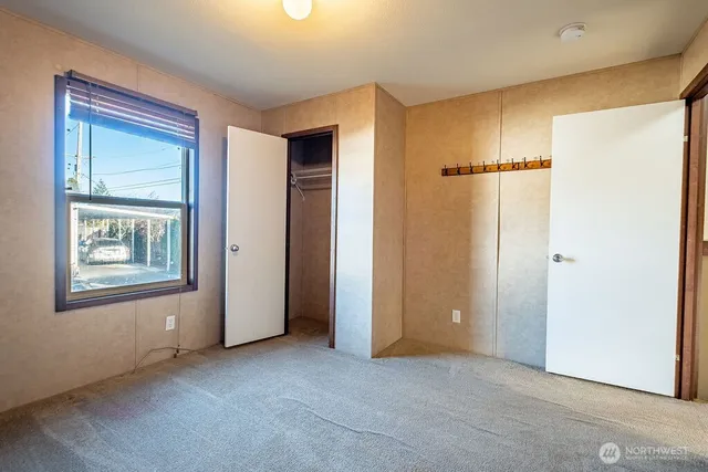 an empty room with windows and closet