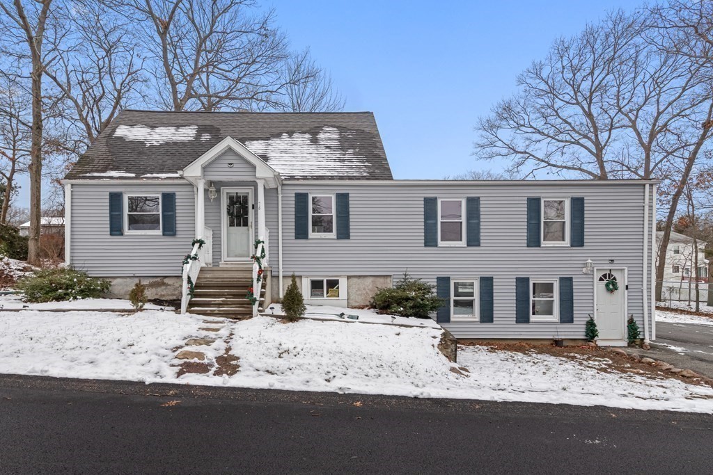 a front view of a house with a yard covered in snow