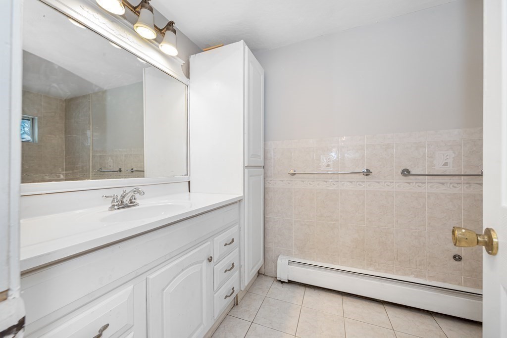 76 Rockefeller Street Randolph, MA 02368 - Photo 11 of 40 a bathroom with a double vanity sink a mirror and a bathtub