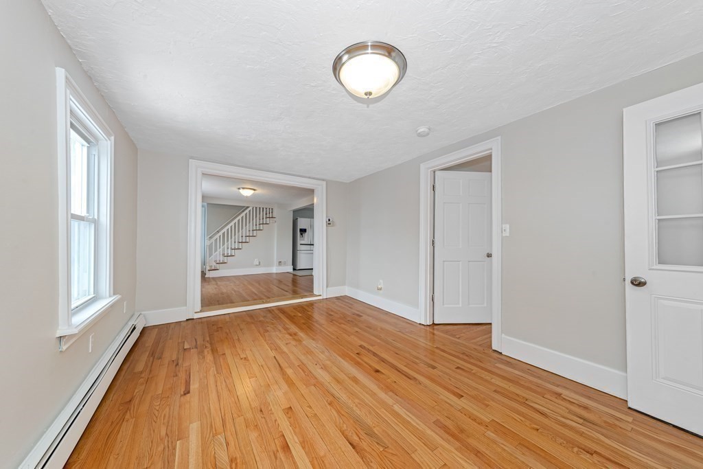 76 Rockefeller Street Randolph, MA 02368 - Photo 15 of 40 a view of empty room with wooden floor and fan