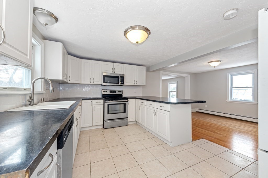 76 Rockefeller Street Randolph, MA 02368 - Photo 7 of 40 a kitchen with granite countertop a sink a counter top space appliances and cabinets