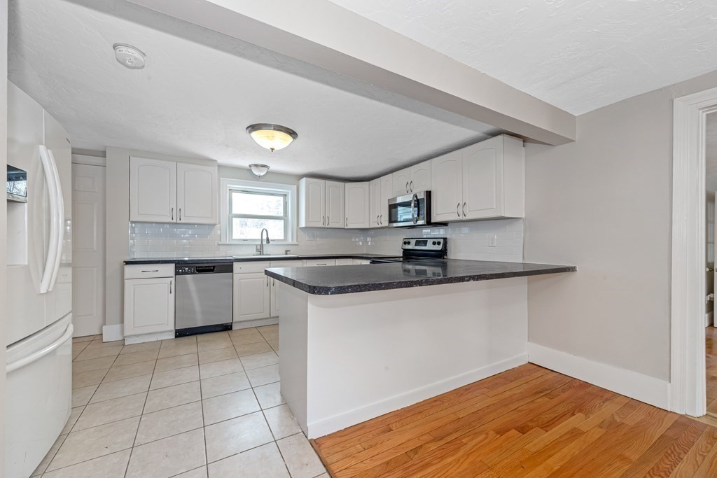 76 Rockefeller Street Randolph, MA 02368 - Photo 8 of 40 a kitchen with stainless steel appliances granite countertop a sink and cabinets