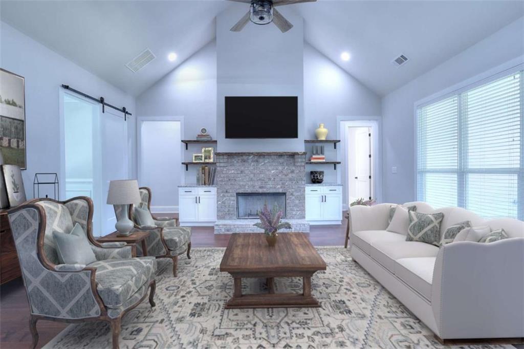 2053 John Stowe Road Monroe, GA 30656 - Photo 13 of 66 a living room with furniture a flat screen tv and a fireplace