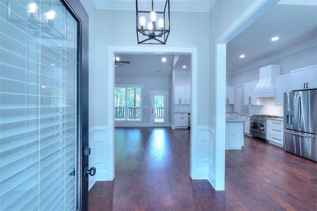 2053 John Stowe Road Monroe, GA 30656 - Photo 15 of 66 a view of a hallway with wooden floor windows and a kitchen