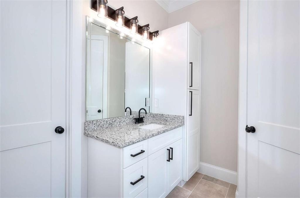2053 John Stowe Road Monroe, GA 30656 - Photo 27 of 66 a bathroom with a granite countertop sink and a mirror