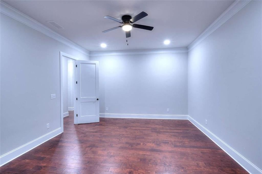 2053 John Stowe Road Monroe, GA 30656 - Photo 47 of 66 an empty room with wooden floor and a ceiling fan