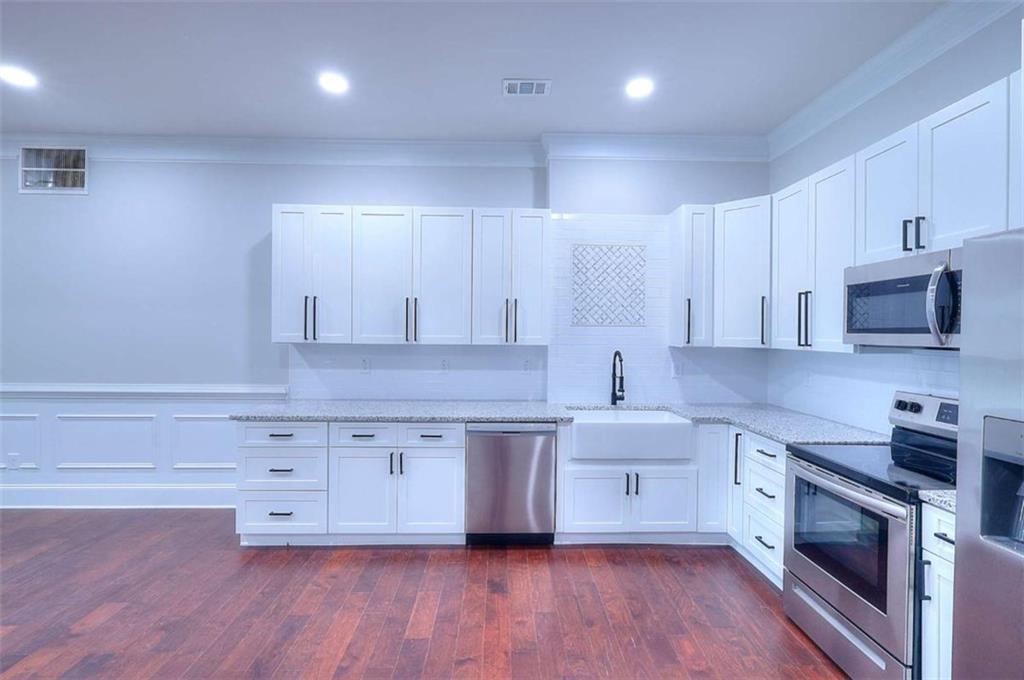 2053 John Stowe Road Monroe, GA 30656 - Photo 48 of 66 a kitchen with stainless steel appliances a sink cabinets and wooden floor
