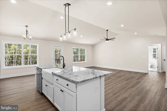 a kitchen with granite countertop white cabinets and a chandelier