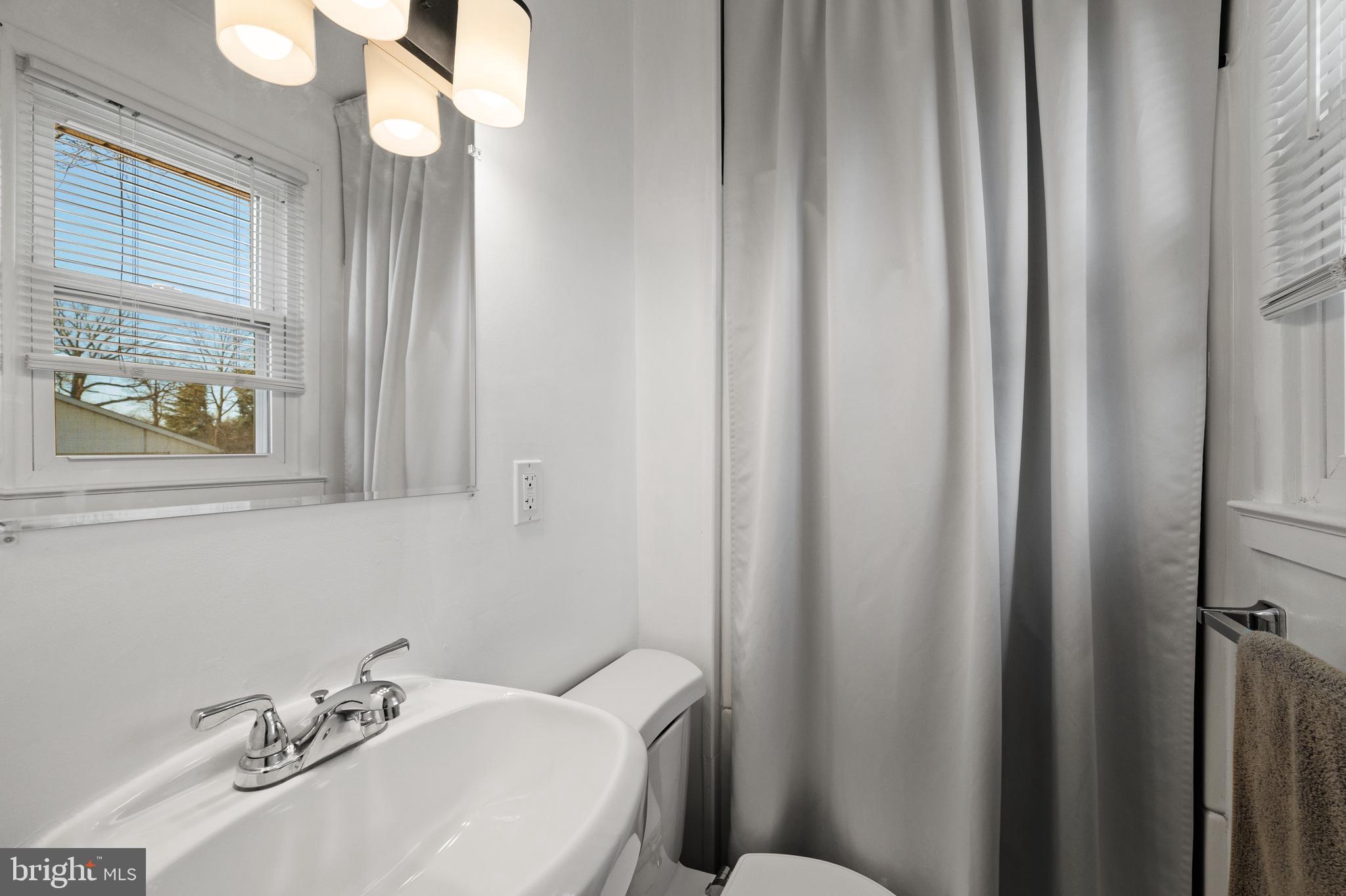 8900 Townsend Lane Clinton, MD 20735 - Photo 15 of 30 a bathroom with a sink a mirror and a window