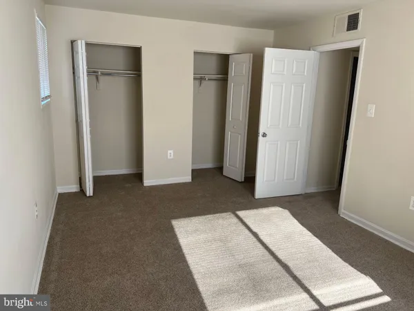 an empty room with closet and mirror