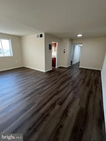 a view of a room with wooden floor and window