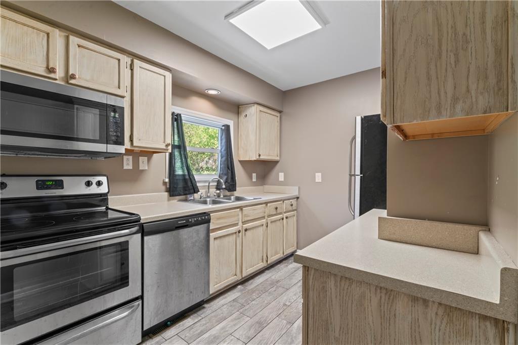 1217 25th Street Beaver Falls, PA 15010 - Photo 17 of 32 a kitchen with stainless steel appliances a stove microwave and sink