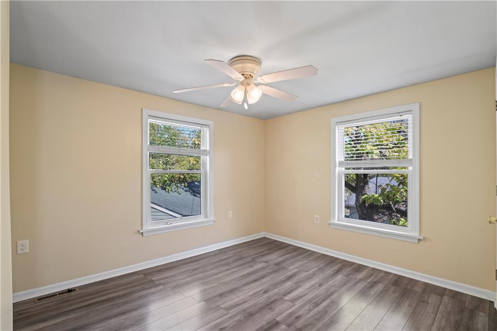 1217 25th Street Beaver Falls, PA 15010 - Photo 22 of 32 a view of a room with window a ceiling fan and wooden floor