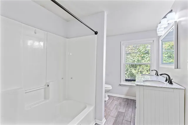 a bathroom with a bathtub a sink a window and a shower