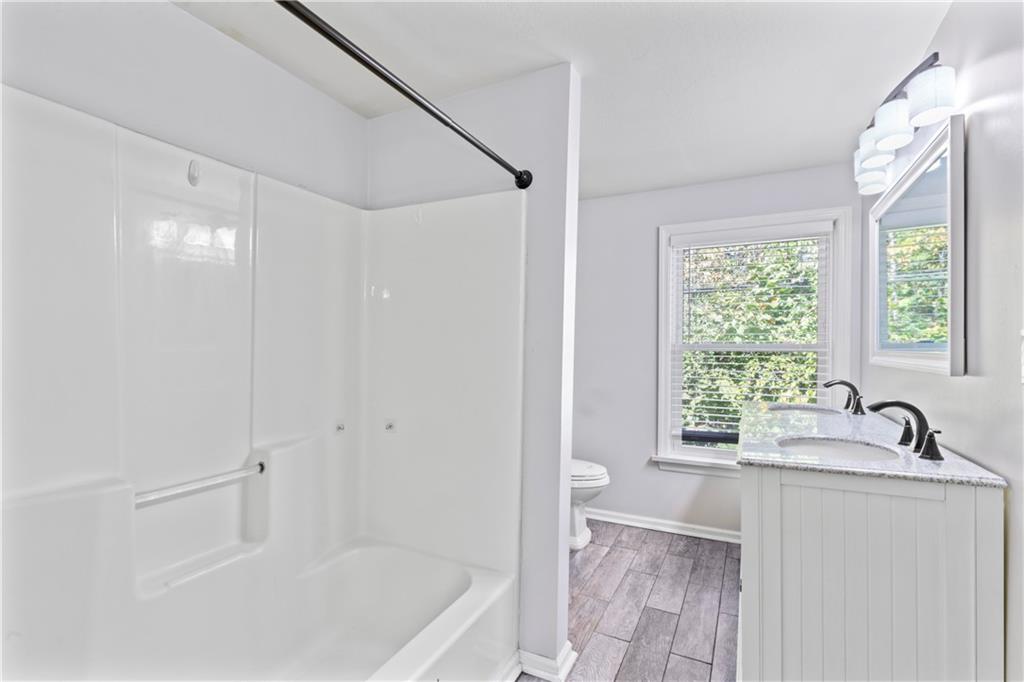 1217 25th Street Beaver Falls, PA 15010 - Photo 24 of 32 a bathroom with a bathtub a sink a window and a shower