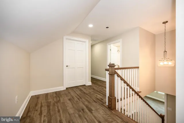 a view of a hallway with wooden floor and staircase