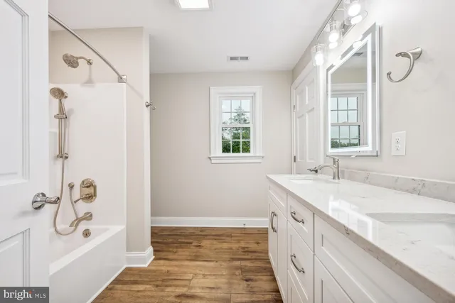 a bathroom with a granite countertop sink a toilet a vanity and shower