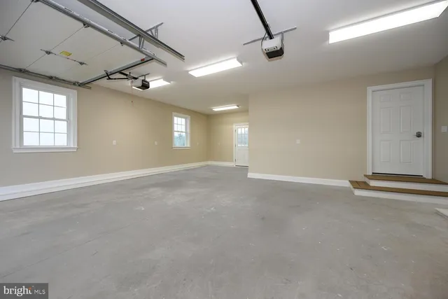 en empty room with windows and ceiling fan