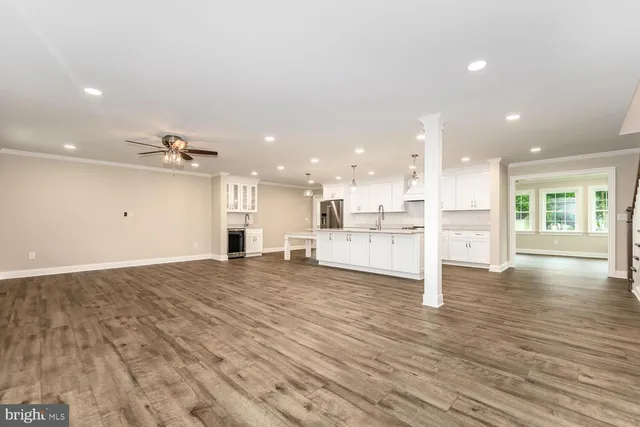 a view of a kitchen with kitchen island wooden floor appliances and a counter top space