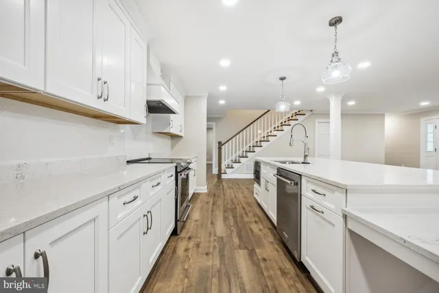 a kitchen with white cabinets appliances and a sink