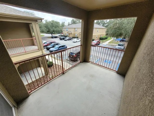 a view of a porch with wooden floor and iron stairs