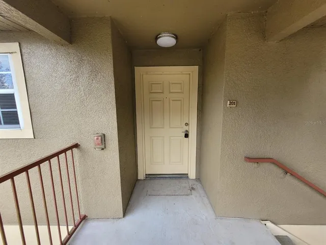 a view of a hallway with wooden floor and closet