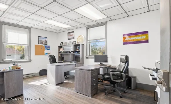 a view of a workspace with furniture and a window