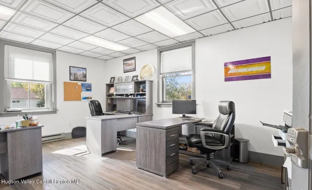 a view of a workspace with furniture and a window