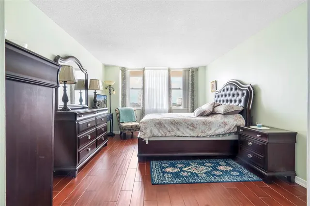a bedroom with a bed wooden floor and window