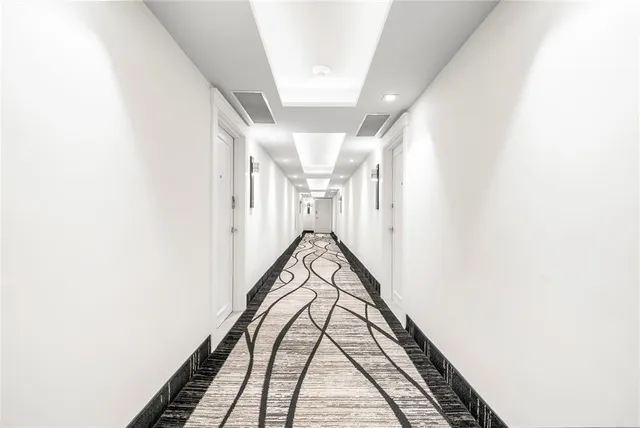 a view of a hallway with wooden floor and white walls