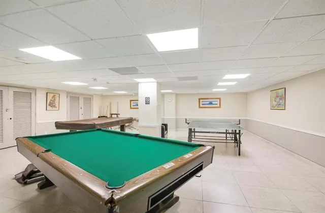 a room with pool table and windows