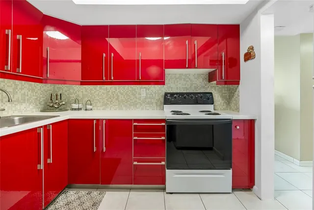 a kitchen with red cabinets and stove