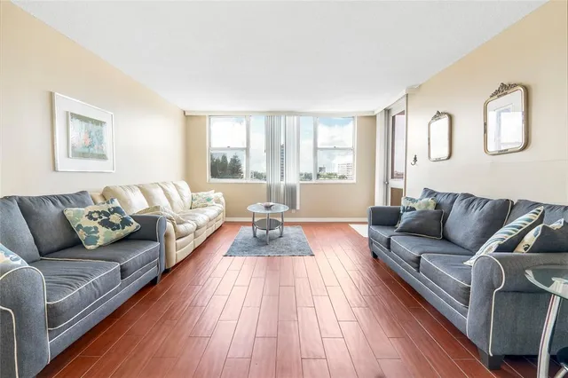 a living room with furniture and a hard wood floor