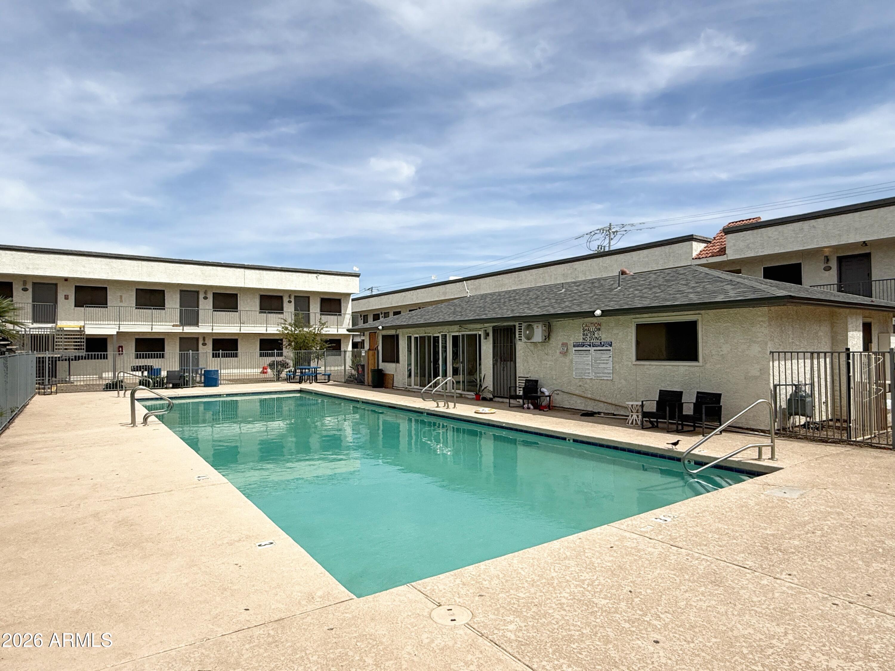 18202 North Cave Creek Road, Unit 148 Phoenix, AZ 85032 - Photo 18 of 19 a view of a house with swimming pool in front of it
