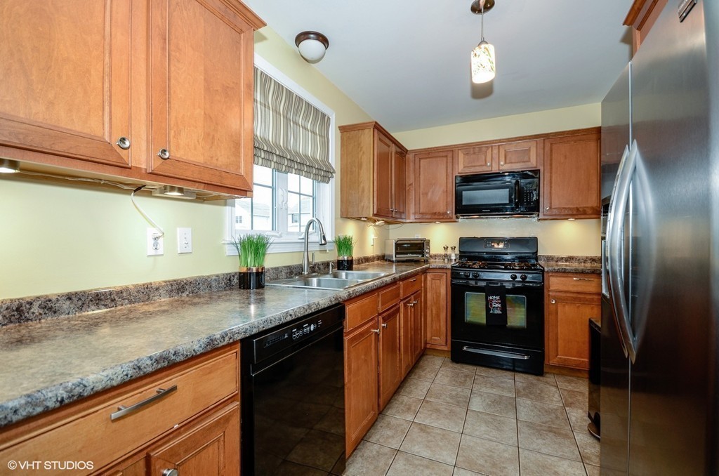 157 Oman Street Fall River, MA 02721 - Photo 9 of 19 a kitchen with stainless steel appliances granite countertop a sink a stove top oven a refrigerator and dishwasher