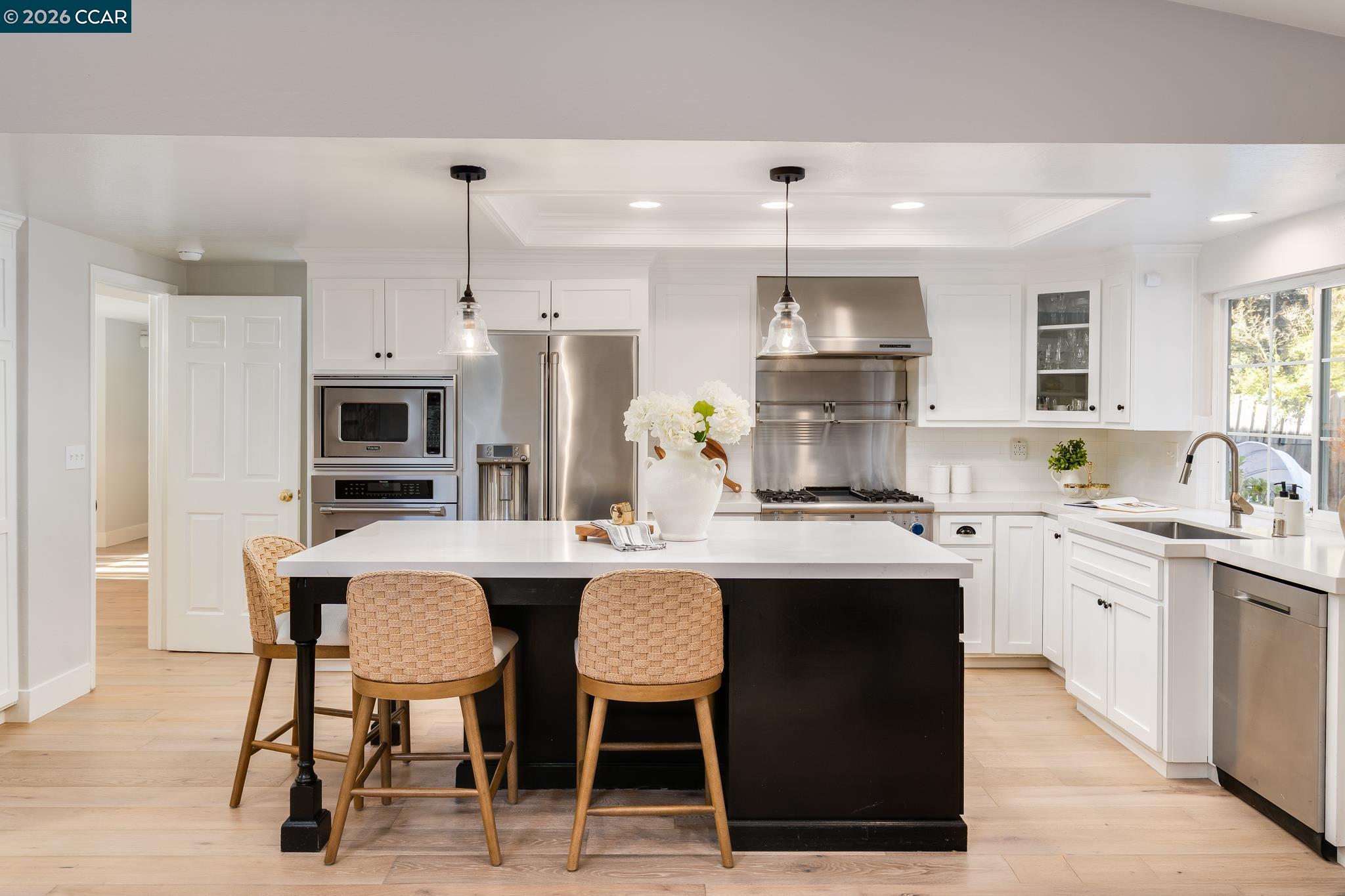 34 Pony Court San Ramon, CA 94583 - Photo 9 of 34 a kitchen with stainless steel appliances granite countertop a sink a stove a refrigerator and a dining table with wooden floor