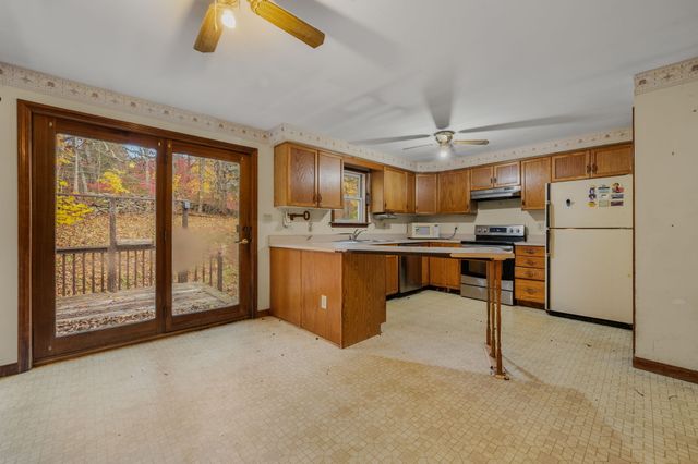 a kitchen with stainless steel appliances kitchen island granite countertop a refrigerator and a stove top oven