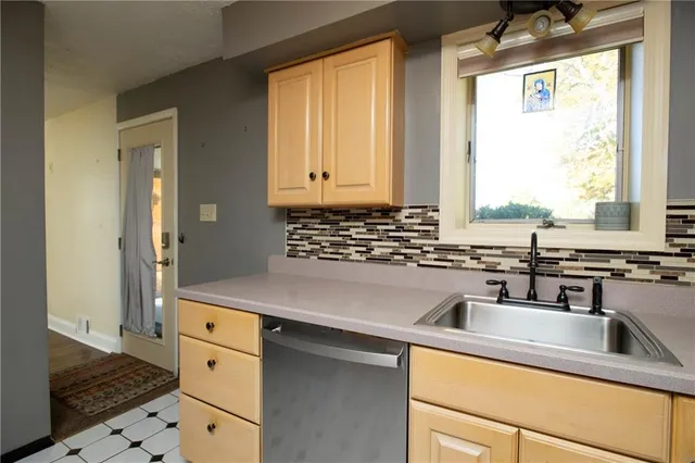 a kitchen with stainless steel appliances sink cabinets and window