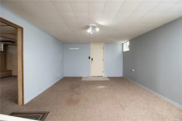 an empty room with staircase and white walls