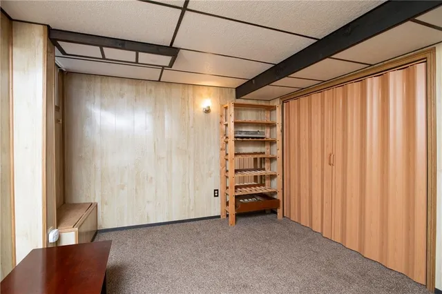 a room with furniture and a washing machine with racks on the wall