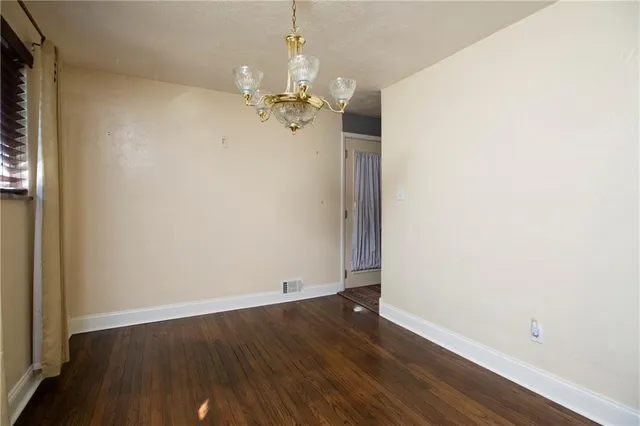 an empty room with wooden floor and ceiling fan