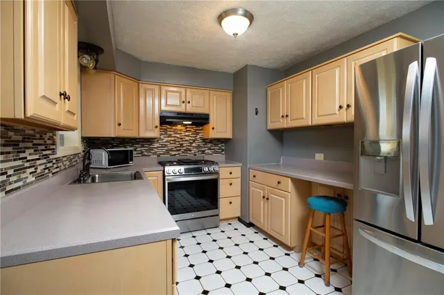 a kitchen with stainless steel appliances granite countertop a refrigerator sink and stove