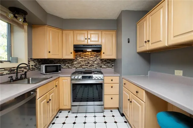 a kitchen with stainless steel appliances a sink stove and cabinets