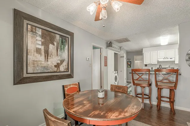 a dining room with wooden floor a glass table and chairs