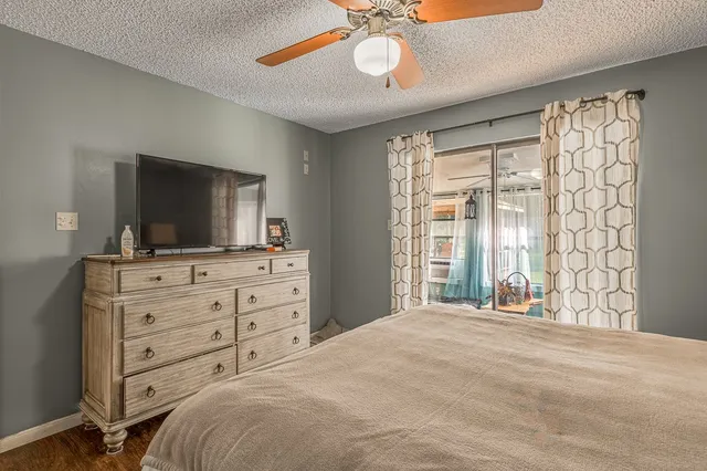 a bedroom with a large bed and a flat tv screen on dresser